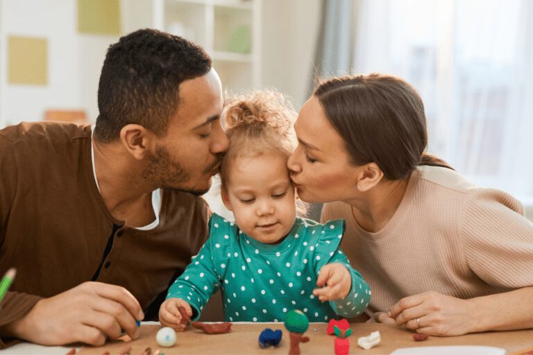 Parents kissing the forehead of their child with food allergy